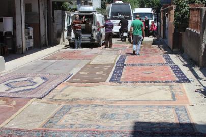 Asfaltlanmayan sokağın tozundan rahatsız olan mahalleli yola halı serdi